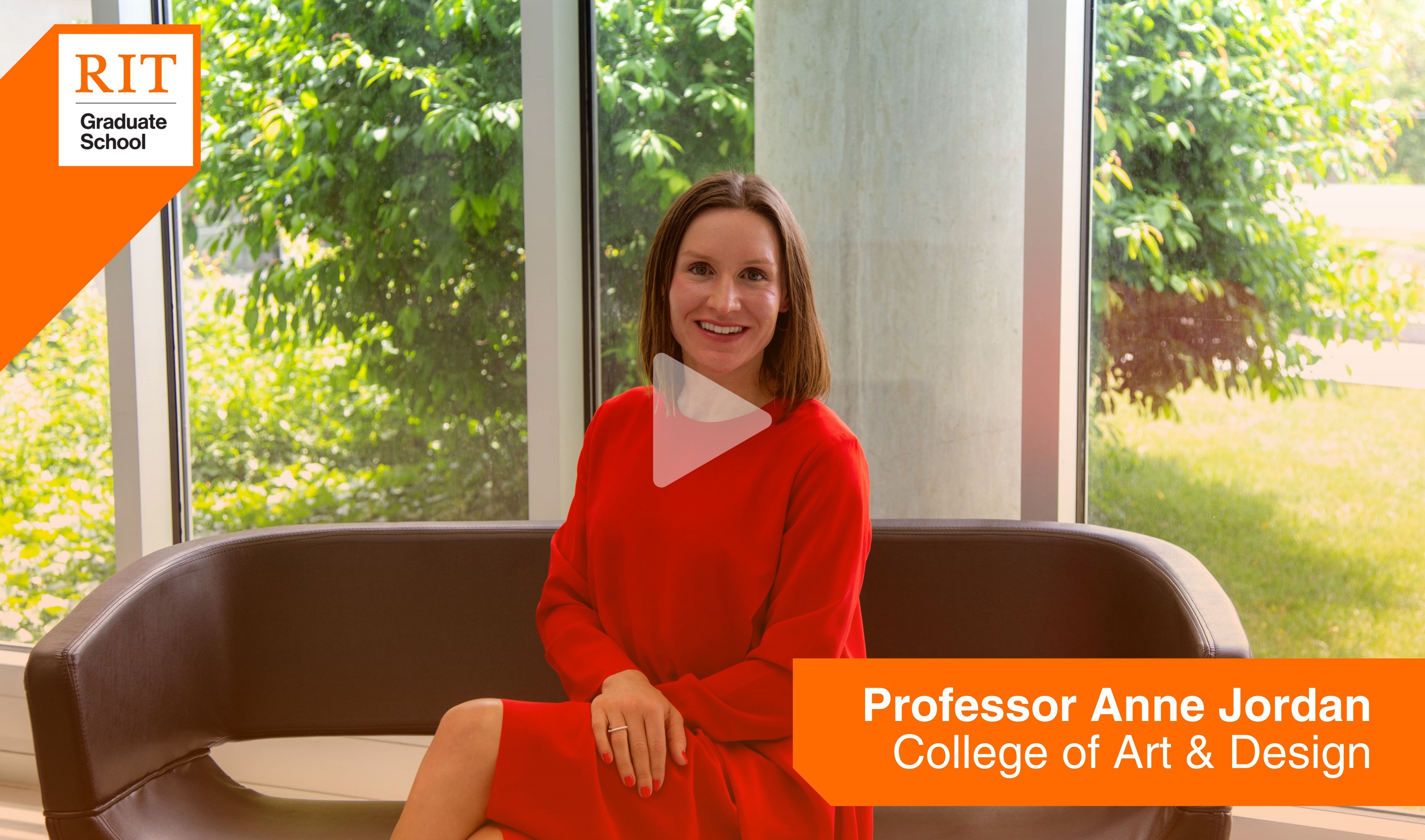Professor Anne jordan sits on a couch for an interview with the Graduate School. click image to watch video