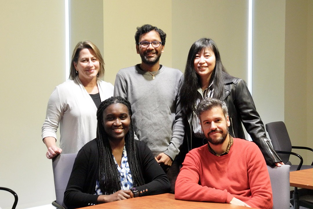 A team of 5 professors smiling