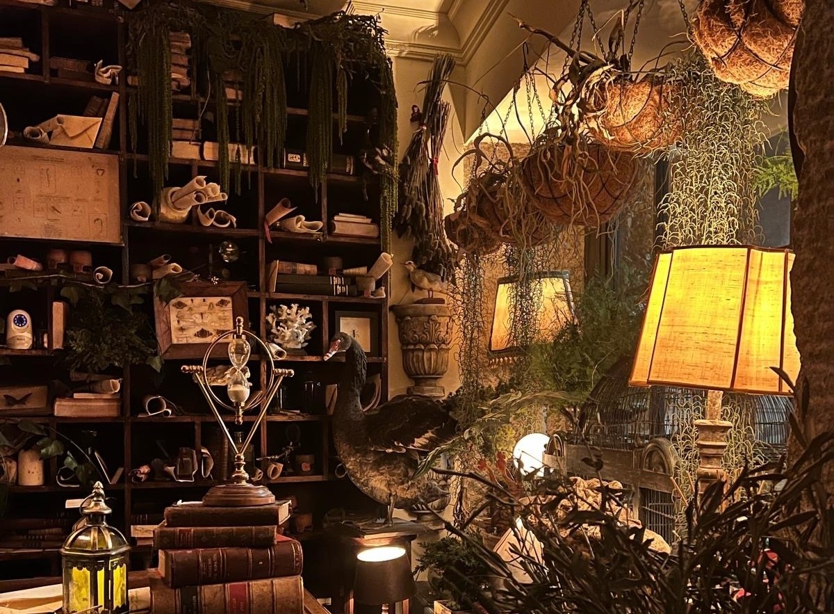 New graduate students sitting on a circular table with one student holding up and showing a gray RIT T-shirt while others smile at the camera