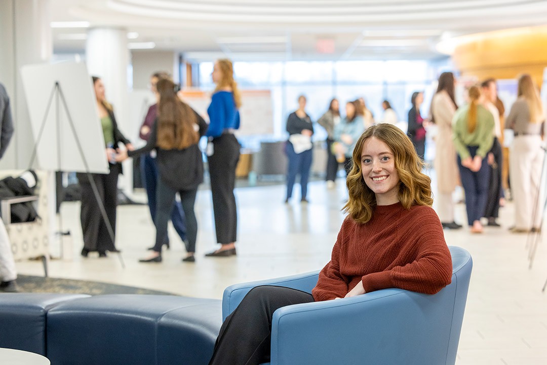 Student Miriam Rigas, sitting on a couch