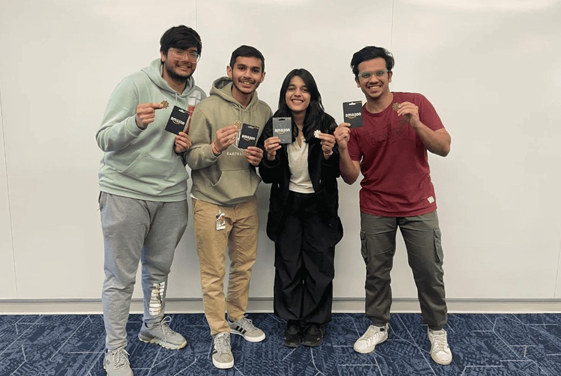 A team of 3 boys and 1 girl pose together as winners of best brickhack.