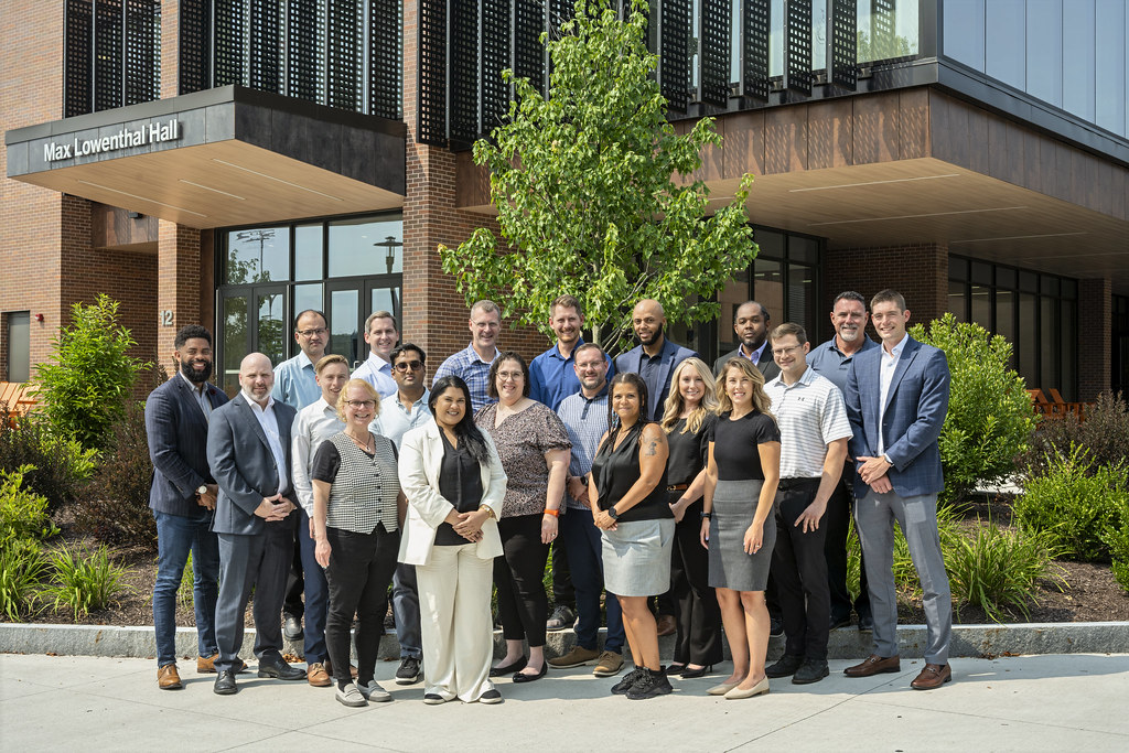A group of people standing outside Max Lowenthal Hall on a sunny day