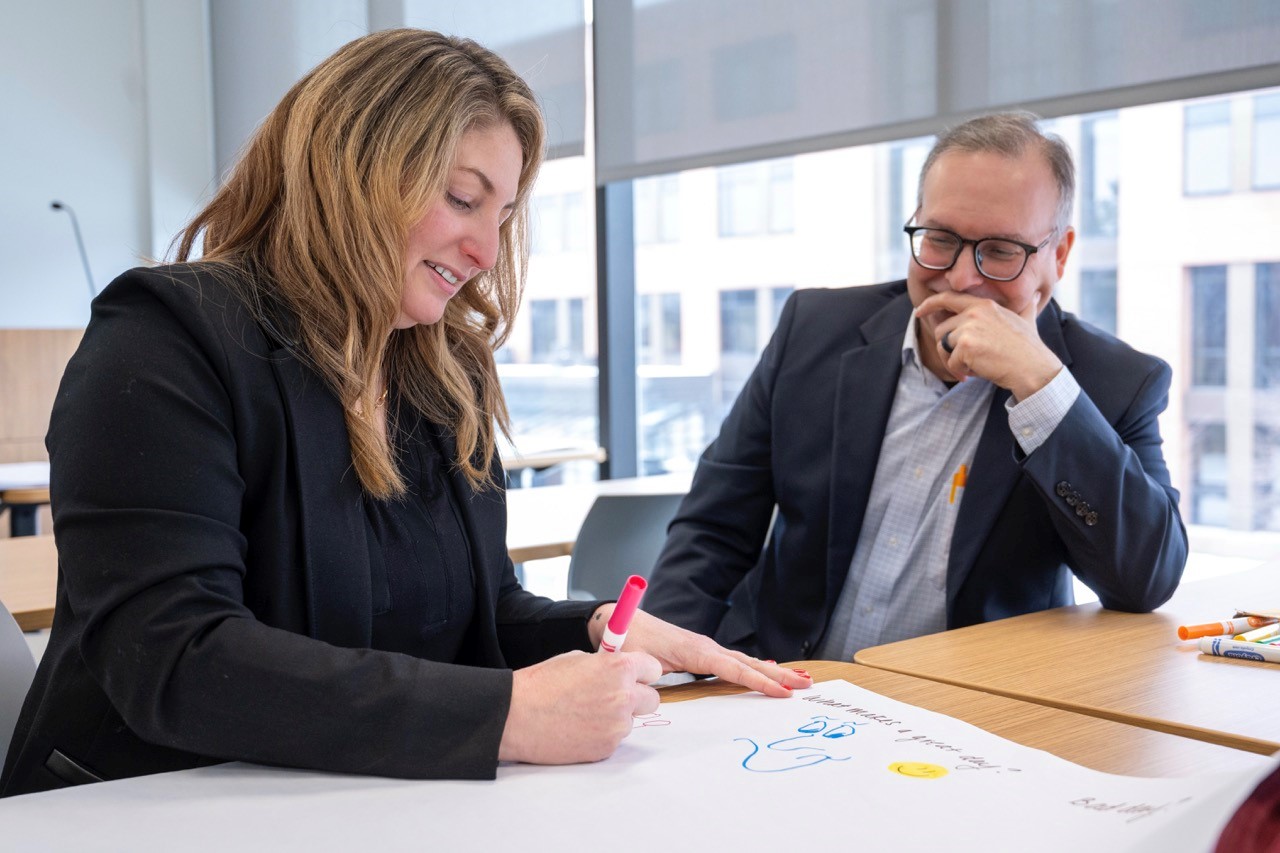 EMBA Students working and smiling