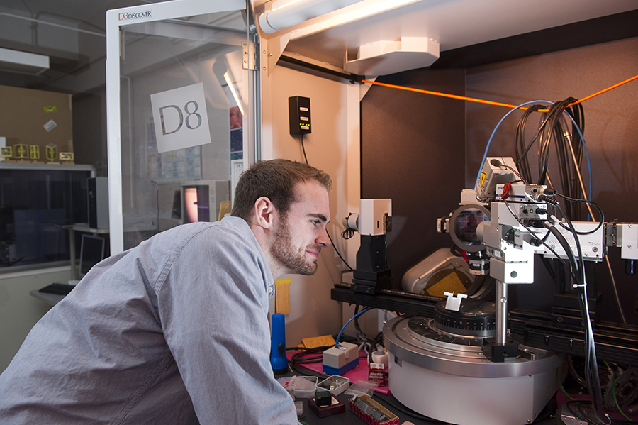 Student looking into equipment in a lab.