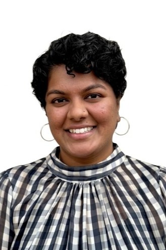 Headshot of Dimple Higdon wearing a black and white patterned blouse.