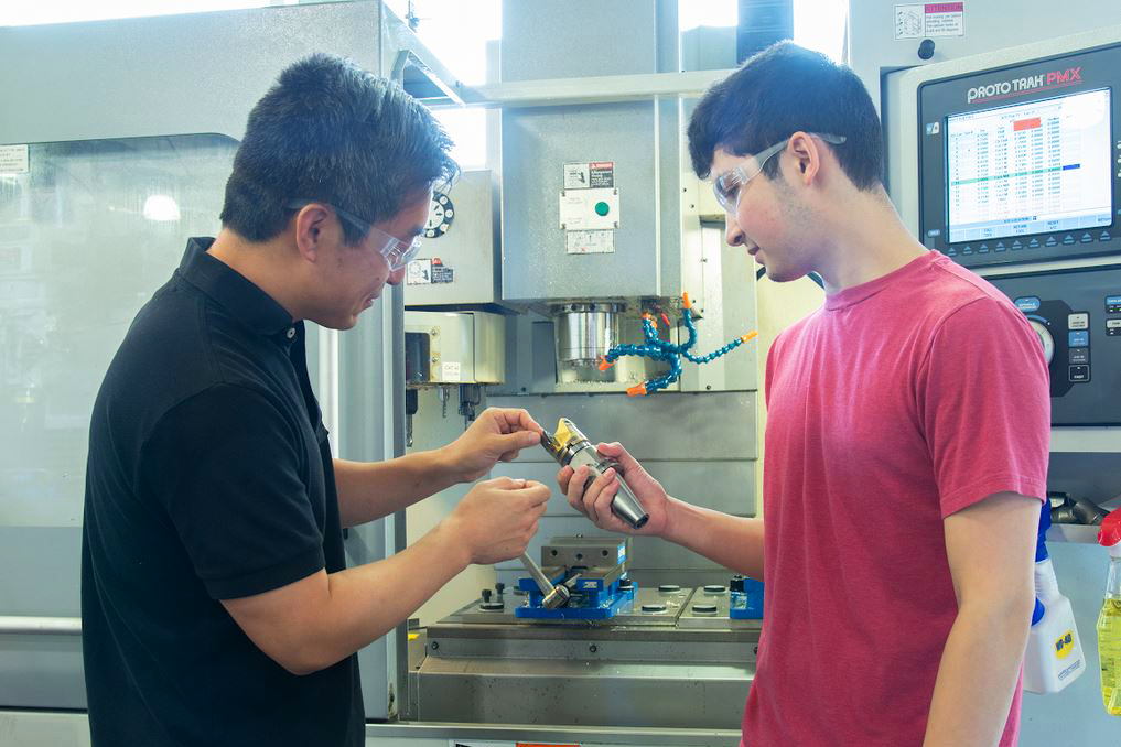 A professor teaching a student in a lab.