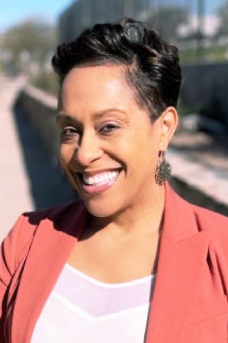 A headshot of Alicia Scott wearing a coral suit jacket.