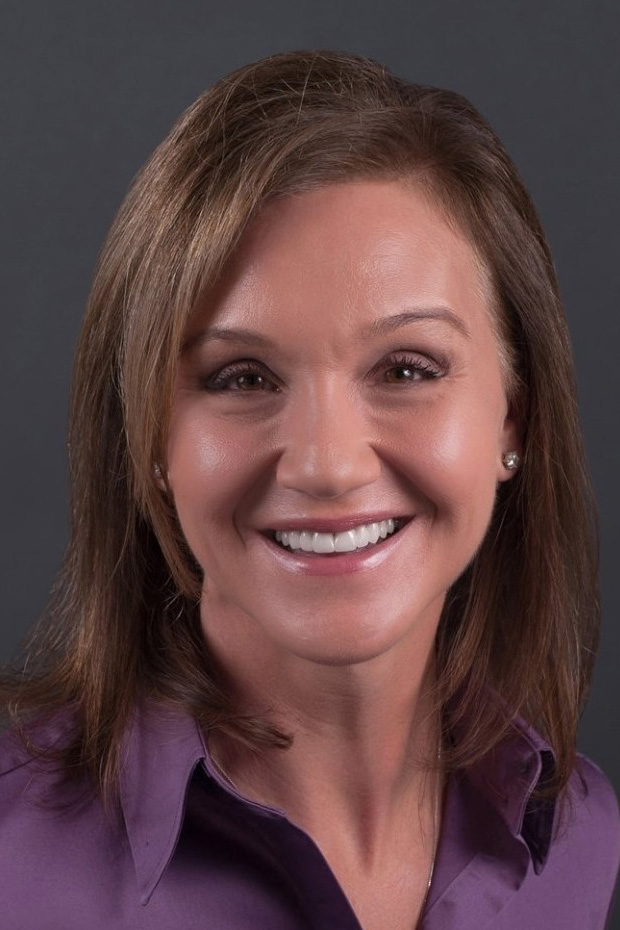 A headshot of Michelle Spina wearing a purple collared shirt.