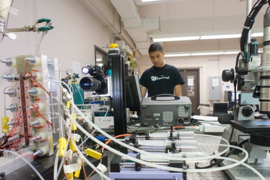 Student working in a lab with lots of testing equipment 