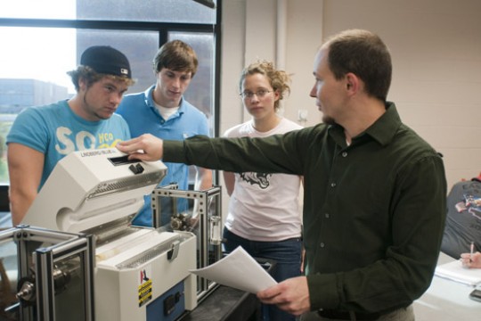 Professor showing students machine