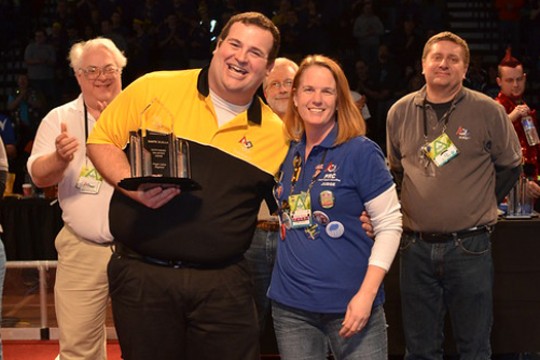 People posing with award at event