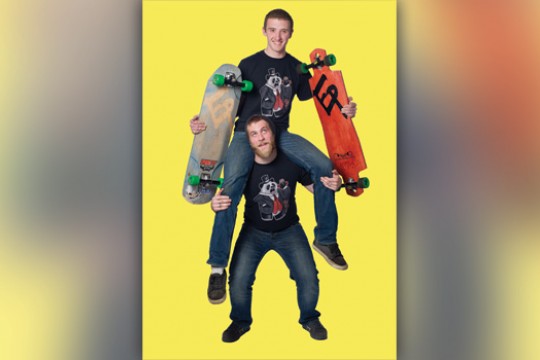 Two people posing with skateboards
