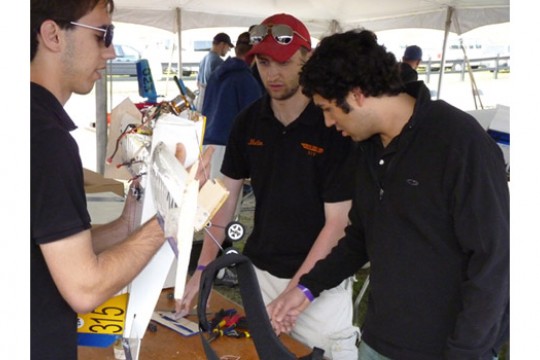 college students looking at a science exhibit.