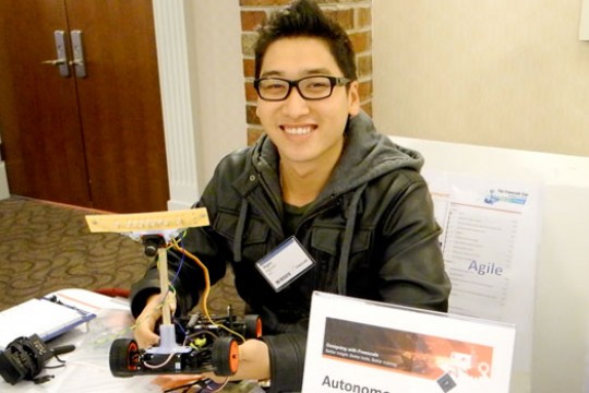 Student posing with robot 