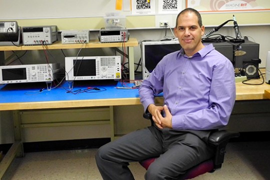 Gill Tsouri sits in an office and poses for a photo.