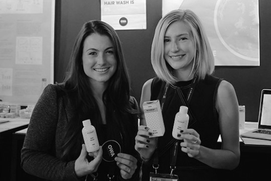 Lindsay Reardon and Kailey Bradt smile for a photo, holding up the products they created.