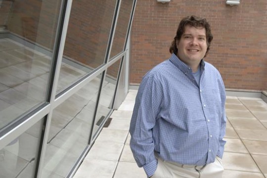 Professor Posing next to classroom building