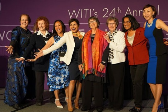 Santosh Kurinec and other honorees excitedly pose for a photo, all of them smiling wide and holding their arms out in triumph.
