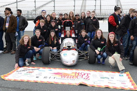 Team posing near formula car