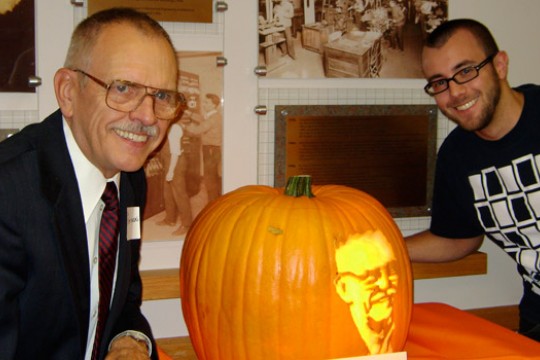People posing around pumpkin