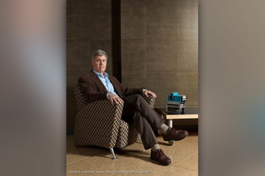 Picture of person sitting in chair next to camera