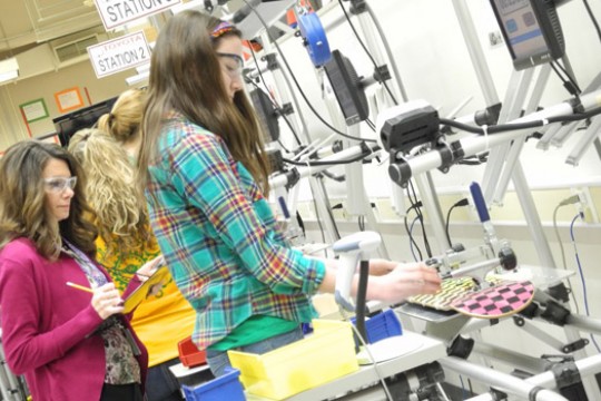 students making skateboards in an assembly line.