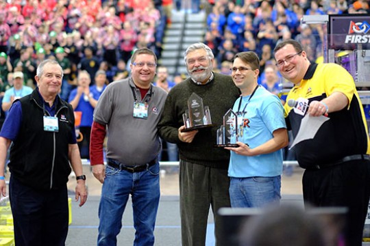 Five people posing for a picture at robotics competition.