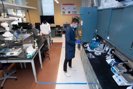 researcher wearing face mask in lab.