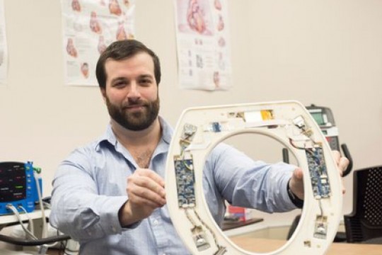 Nicholas Conn holding prototype of smart toilet seat