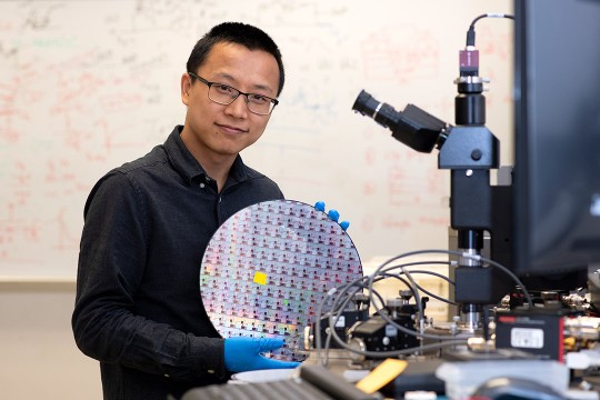 professor holding large, round silicon wafer.