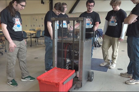 Rochester Institute of Technology engineering students show off a device Tuesday, April 28, 2026, meant to help employees at Classified Scanning & Shredding lift heavy items like totes.