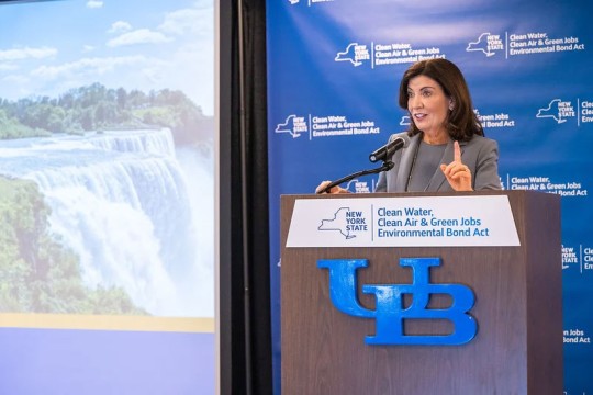 New York Governor Kathy Hochul speaks at a podium promoting the Clean Water, Clean Air & Green Jobs Environmental Bond Act at the University at Buffalo.