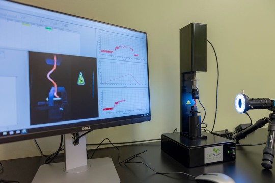 Biomedical device and computer monitor displaying data and graphs.