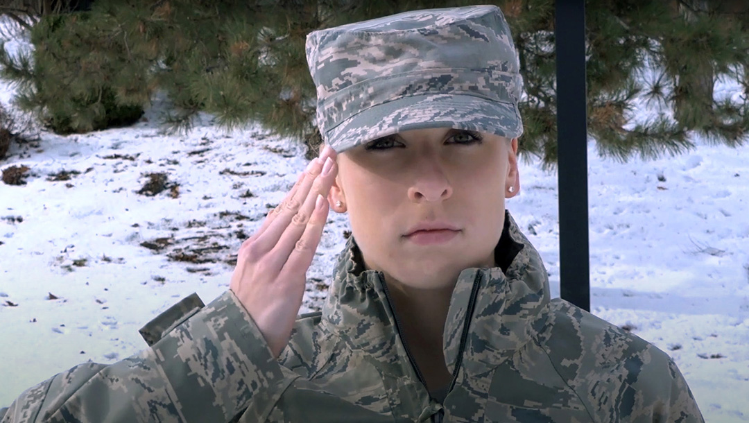 Female in uniform, saluting.