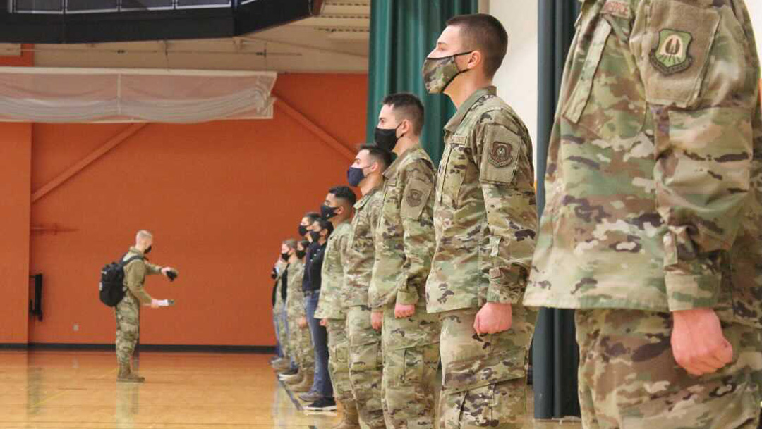 People in uniform standing in line, in a gym.