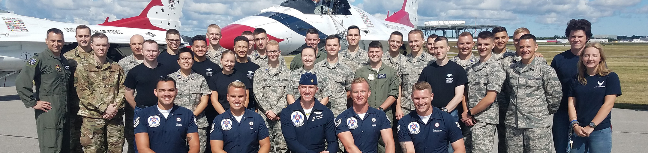 Air Force ROTC members posing in front of 2 jets.