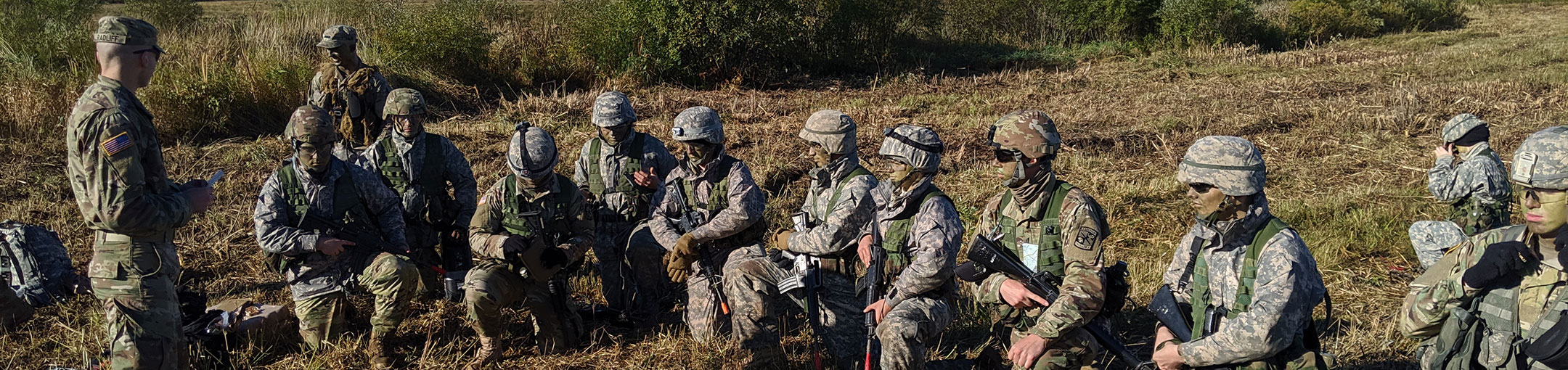 Army ROTC students in field with training rifles.