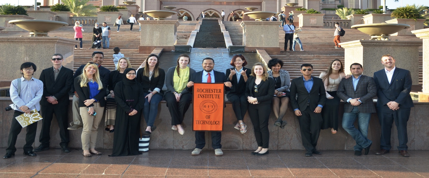 A photo of students holding the RIT flag infront HotelPalace in AbuDubai
