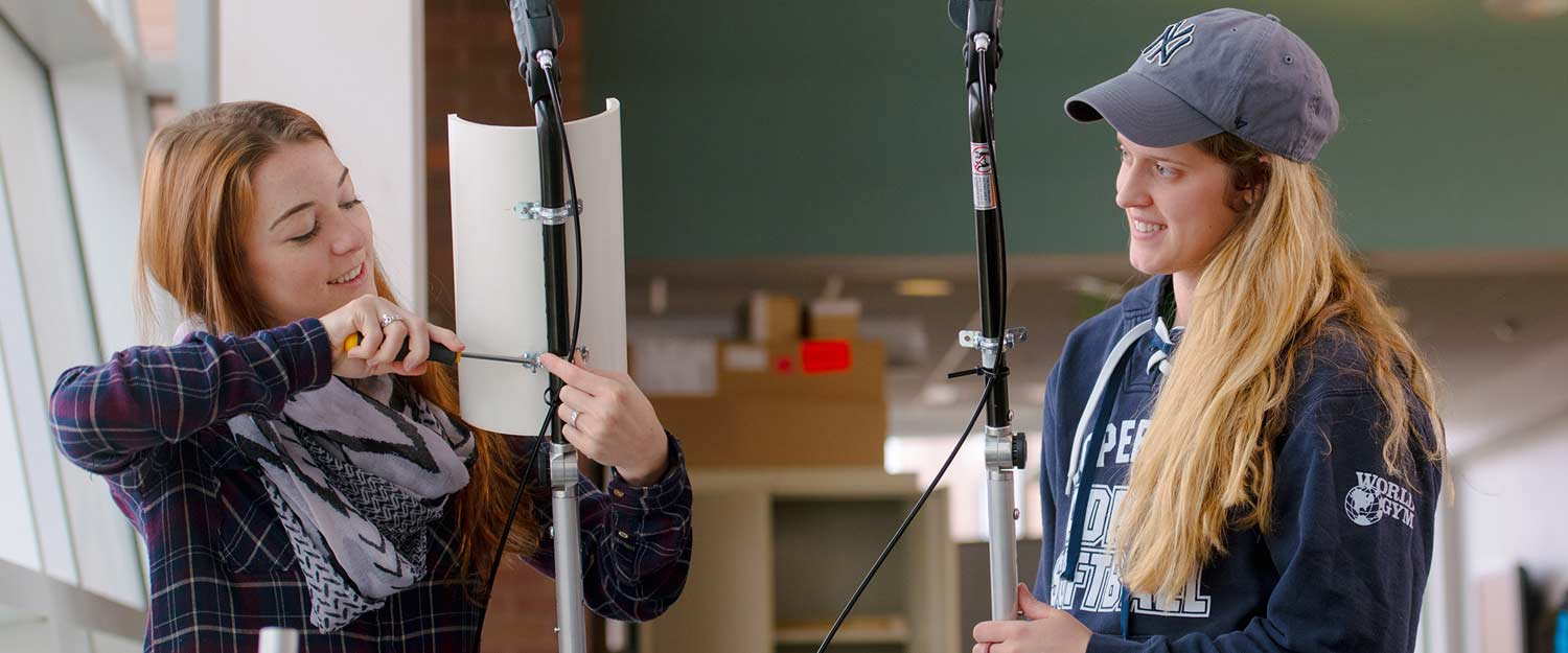 Two students setting up equipment for an experiment