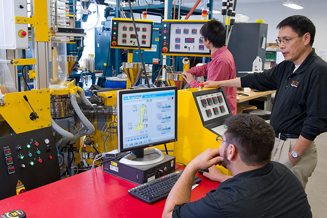 A group of three people calibrating machinery