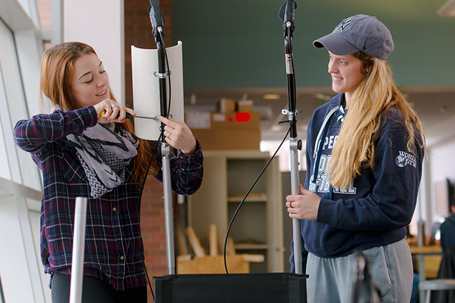 Two women working on setting up equipment