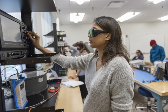 Student looking at equipment studying light 