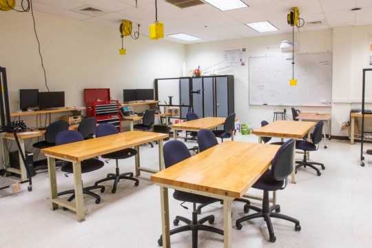 Class room with four tables and outlets accessible from the ceiling