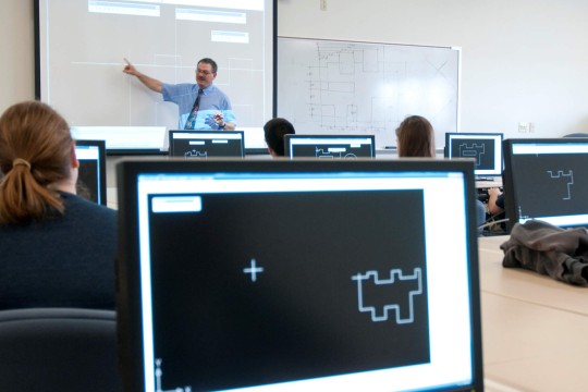 Interior view of the Design and Drafting Lab, showing students working at computers.