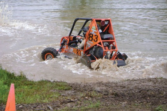 Off road vehicle driving along dirt course