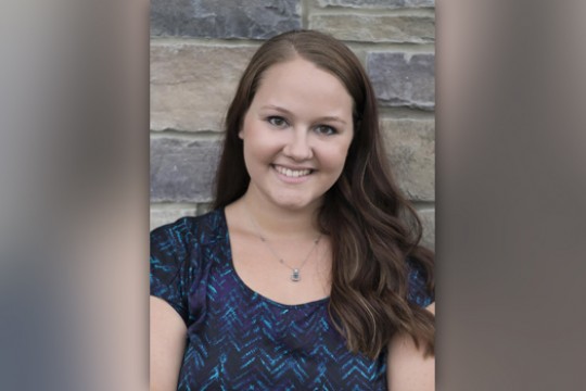 Person posing for camera in front of wall
