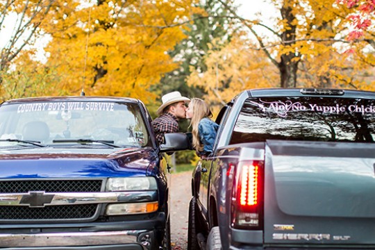 People kissing from between two trucks