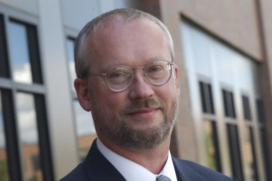 Professor Standing in front of building