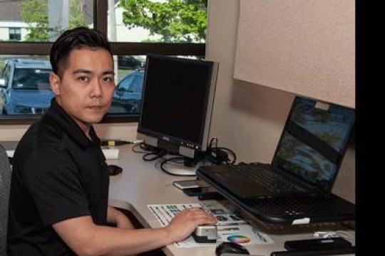 Student sits at desk with computer.