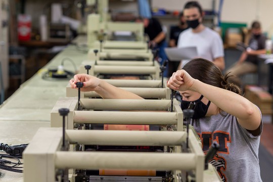 student adjusting printing machinery.